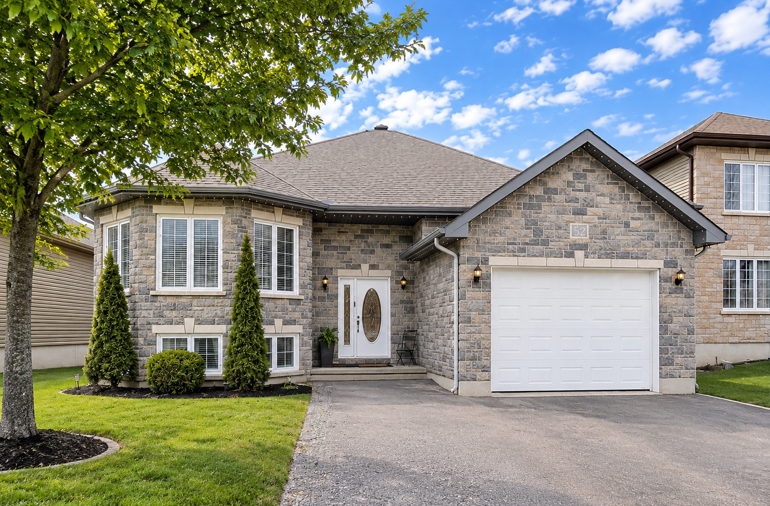 Suburban Stone Bungalow Framed by Trees